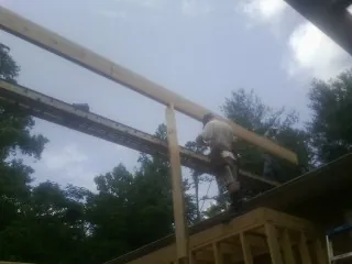 Carpenter setting a ridge beam over a new addition frame — Ice Dam Removal by Roofing Brothers in Camp Dennison