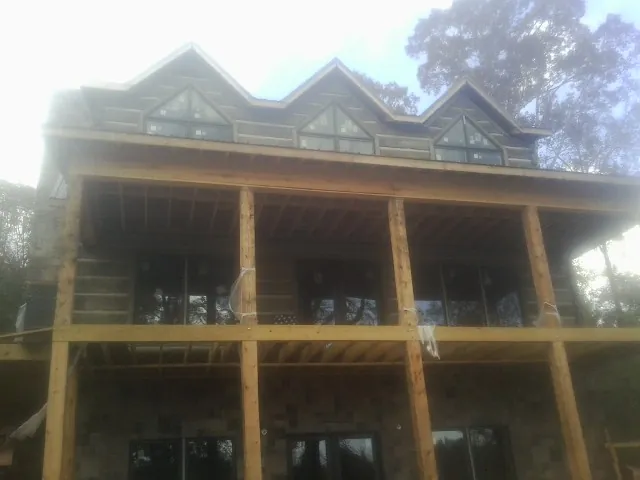 Dormers and porch framing on a large log home under construction — Roof Coating work by our crew in Camp Dennison