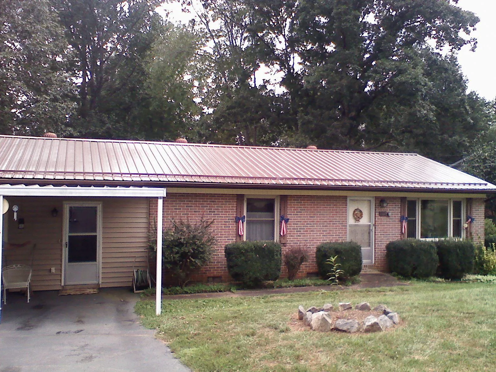 Bronze metal roof and carport on a brick ranch home — Roof Repair work by our crew in Camp Dennison